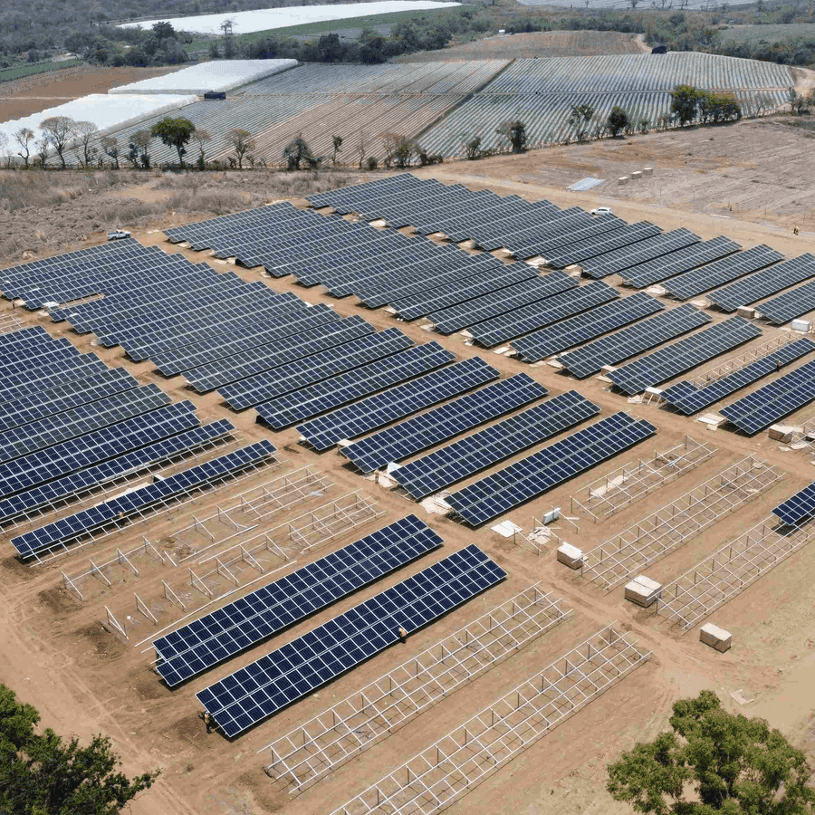Vista aérea del parque solar en construcción, con filas de paneles instaladas y estructuras de montaje aún pendientes
